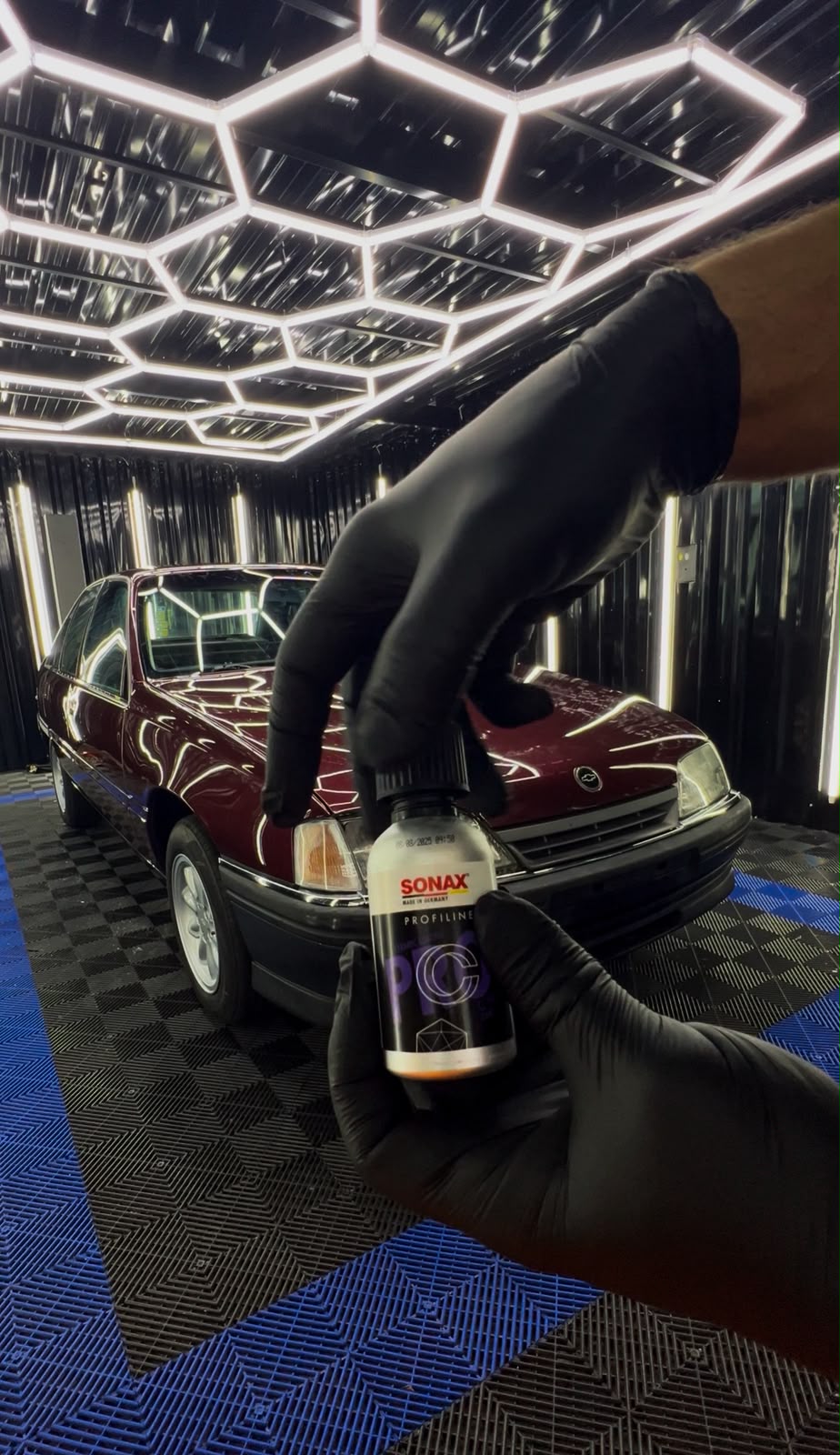 Aplicação de produto de correção da pintura em veículo sob iluminação de LED no estúdio Eagle Detailers Premium